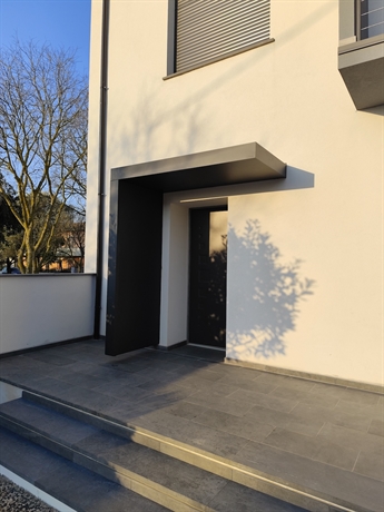 Pensilina design con paravento laterale installata a Sedilo in Sardegna su ingresso moderno